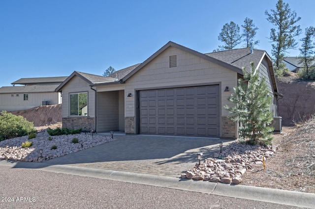 211 S Thunder Mtn, Payson, AZ 85541 - ranch-style home with stone siding, an attached garage, decorative driveway, roof with shingles, and cooling unit