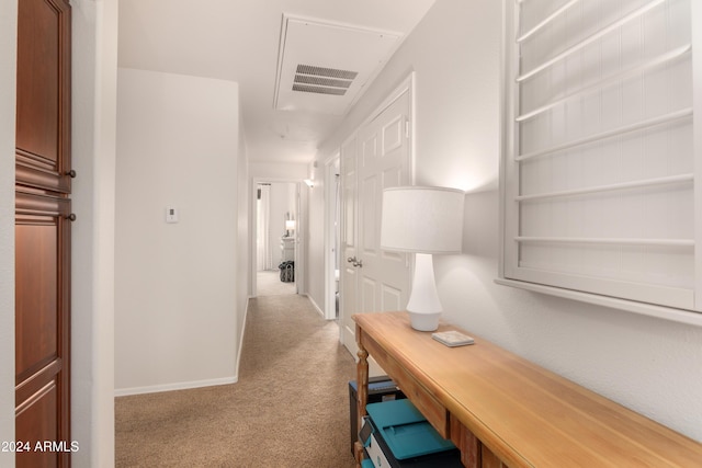 corridor featuring baseboards and light colored carpet