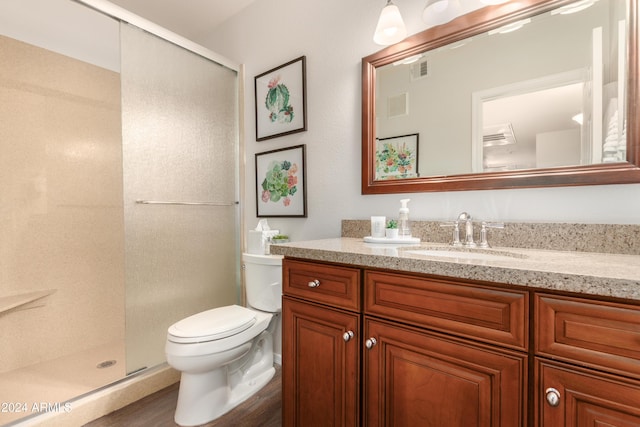 bathroom with a stall shower, visible vents, vanity, and toilet