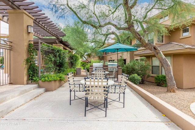 view of patio with fence, an outdoor kitchen, a pergola, and outdoor dining space