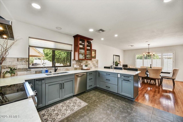 kitchen featuring a sink, dishwasher, light countertops, a peninsula, and visible vents