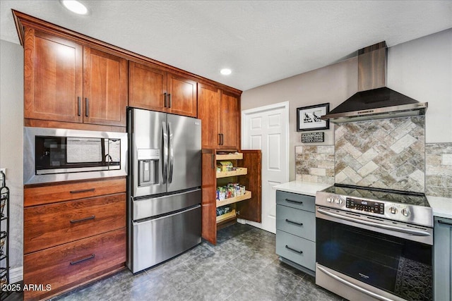 kitchen featuring backsplash, appliances with stainless steel finishes, wall chimney exhaust hood, and light countertops