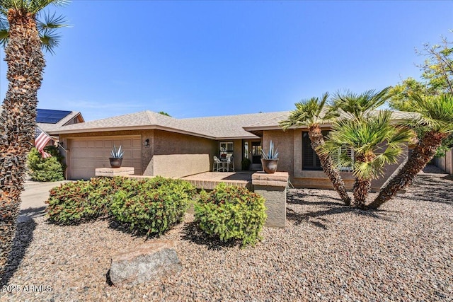 ranch-style house featuring stucco siding and a garage