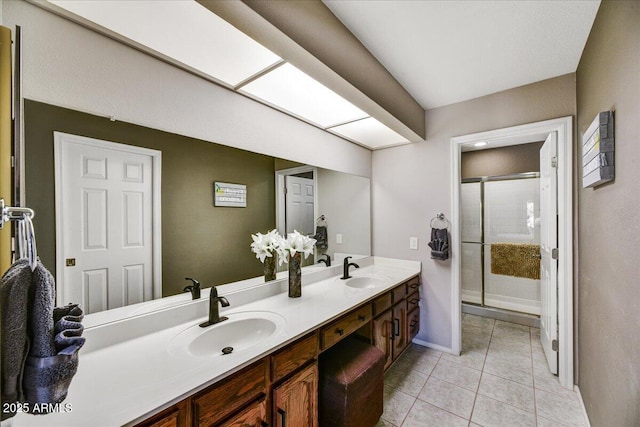 bathroom featuring baseboards, a sink, a stall shower, and double vanity