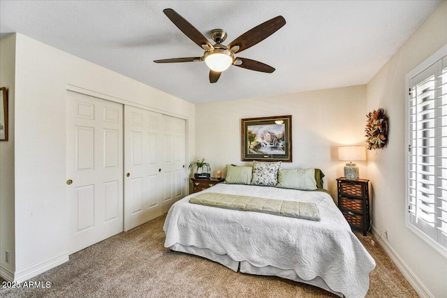 carpeted bedroom featuring a closet, a ceiling fan, baseboards, and multiple windows