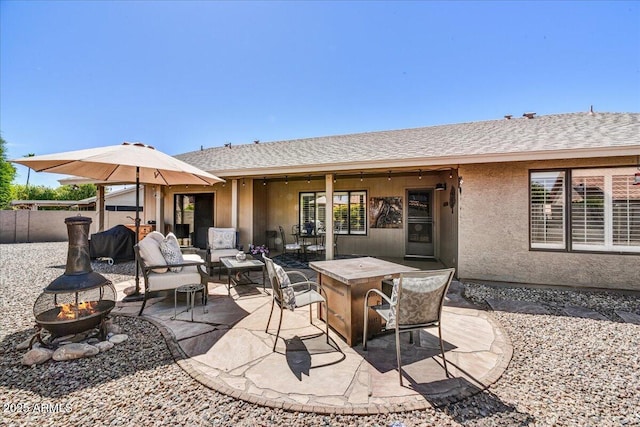 view of patio / terrace with fence and an outdoor living space with a fire pit