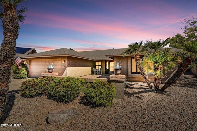 view of front of property with a garage, stucco siding, and concrete driveway