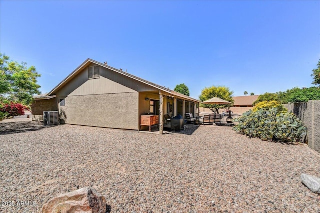 rear view of house with a patio, fence, and cooling unit