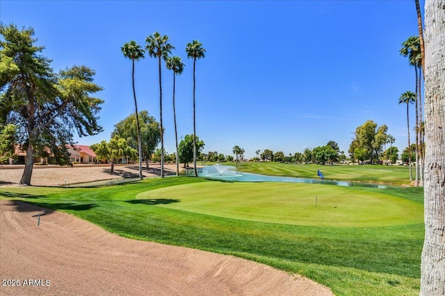 view of community featuring a lawn, a water view, and view of golf course