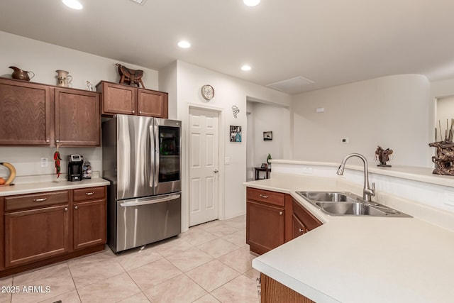 kitchen featuring stainless steel refrigerator, sink, and light tile patterned floors