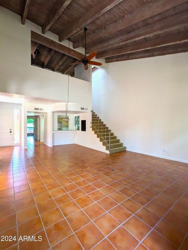 interior space featuring ceiling fan, visible vents, wood ceiling, tile patterned floors, and beamed ceiling