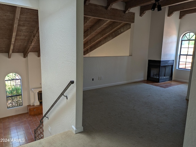 unfurnished living room featuring baseboards, a textured wall, tile patterned floors, carpet floors, and a multi sided fireplace