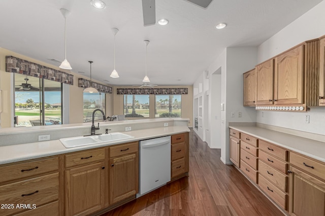 kitchen featuring ceiling fan, dark wood-style flooring, a sink, light countertops, and dishwasher