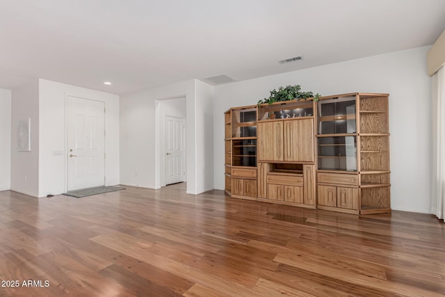 unfurnished living room featuring recessed lighting, visible vents, and wood finished floors