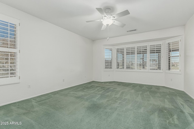 spare room featuring carpet, visible vents, and ceiling fan