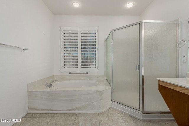 bathroom with a stall shower, tile patterned floors, a garden tub, and vanity