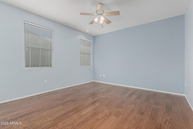 spare room with a ceiling fan, baseboards, and wood finished floors