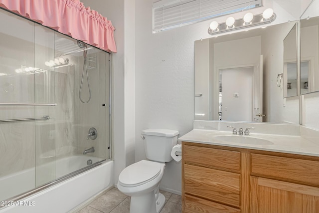 full bath featuring vanity, shower / bath combination with glass door, tile patterned flooring, and toilet