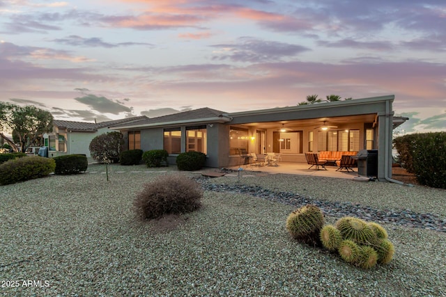 back of house featuring a ceiling fan, a patio area, and stucco siding