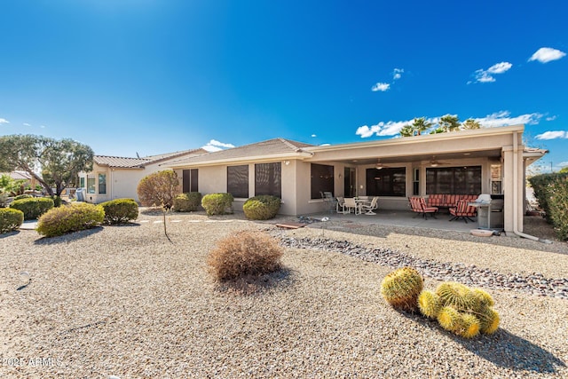 ranch-style house featuring ceiling fan, outdoor lounge area, a patio area, and stucco siding