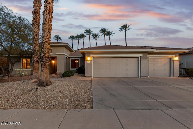 prairie-style house with a garage, concrete driveway, and stucco siding