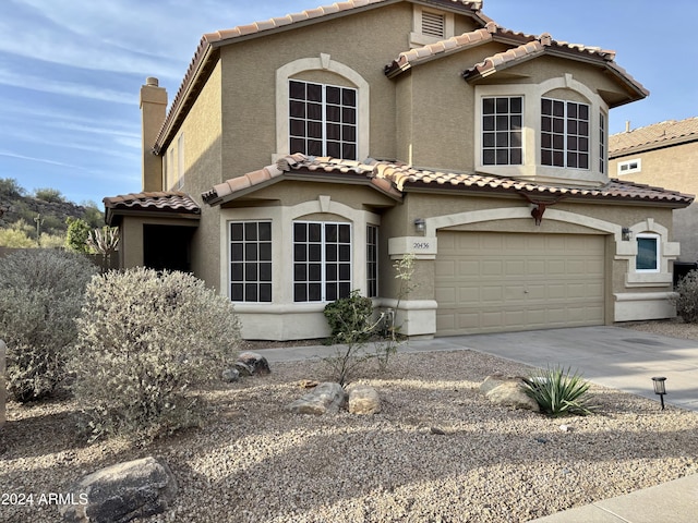 mediterranean / spanish-style house featuring driveway, a garage, a tile roof, a chimney, and stucco siding