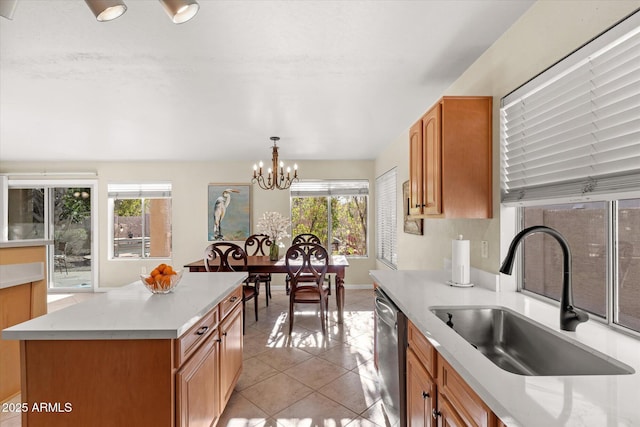 kitchen featuring dishwasher, a center island, a notable chandelier, sink, and decorative light fixtures