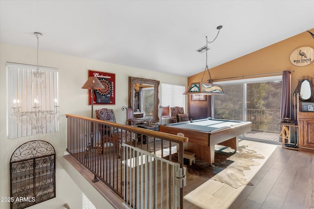 rec room with lofted ceiling, billiards, a chandelier, and hardwood / wood-style flooring