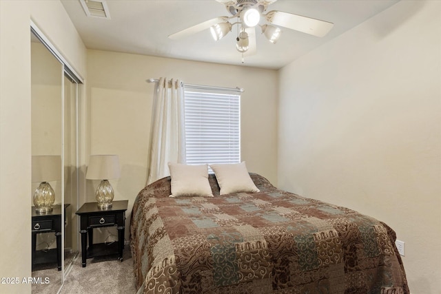 bedroom with light colored carpet, ceiling fan, and a closet