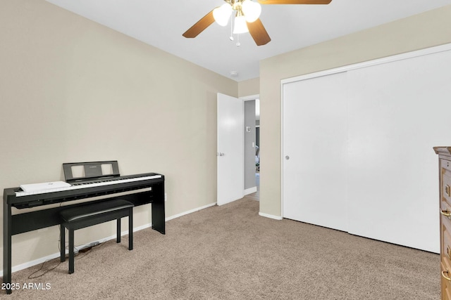 sitting room featuring baseboards, a ceiling fan, and carpet floors