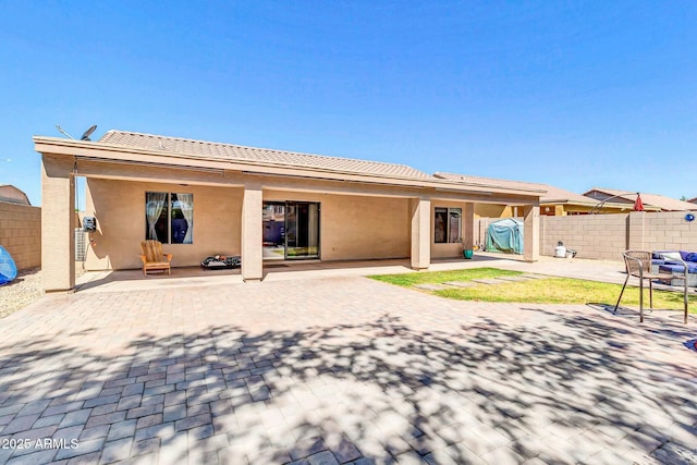 back of house featuring a patio area, fence, and stucco siding