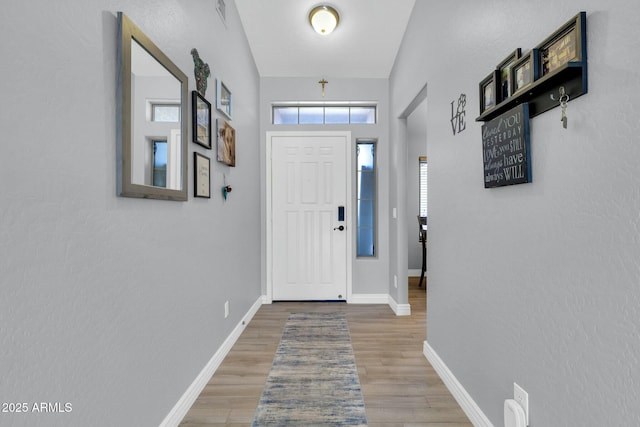 entryway with light wood-style floors, baseboards, and visible vents