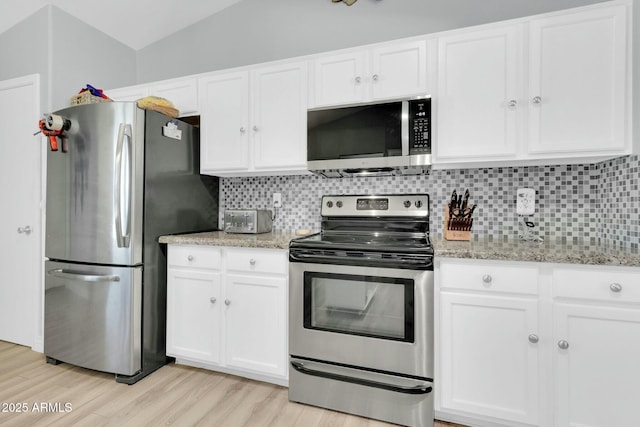 kitchen with stainless steel appliances, tasteful backsplash, and white cabinetry