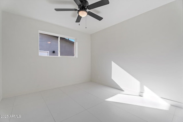 tiled spare room with ceiling fan