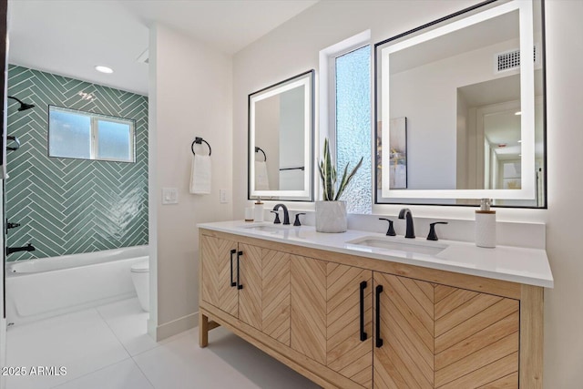 full bathroom with toilet, tiled shower / bath, tile patterned floors, and vanity