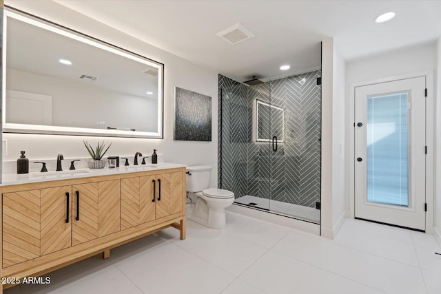 bathroom with vanity, a tile shower, tile patterned floors, and toilet