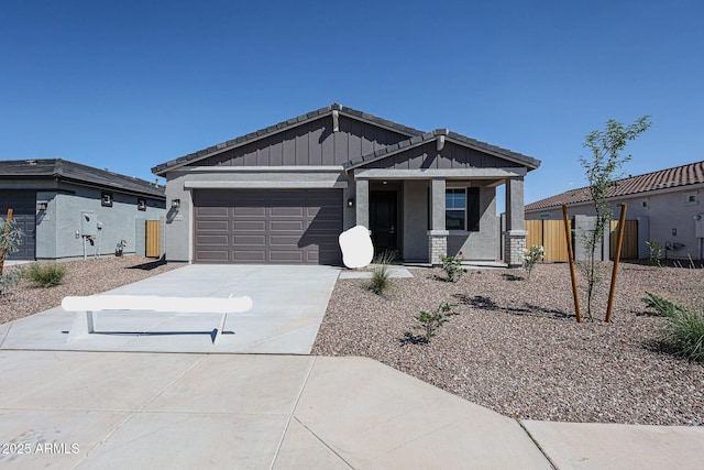 19115 N Los Gabrieles Way, Maricopa, AZ 85138 - view of front of home with board and batten siding, driveway, an attached garage, fence, and covered porch