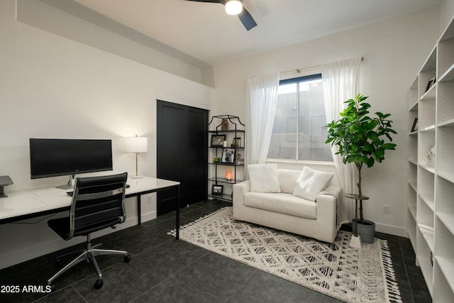 home office featuring dark tile patterned flooring and ceiling fan