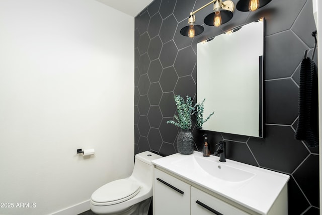 bathroom with tile walls, toilet, vanity, and decorative backsplash