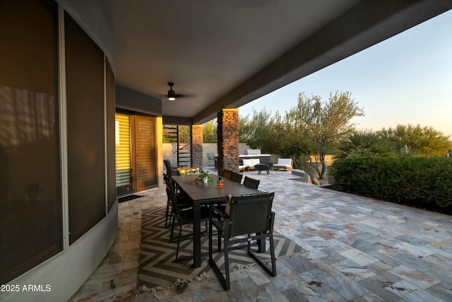 patio terrace at dusk featuring ceiling fan