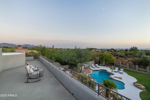 pool at dusk featuring a patio area and a mountain view