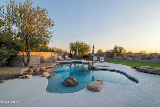 pool at dusk featuring a patio area and a yard