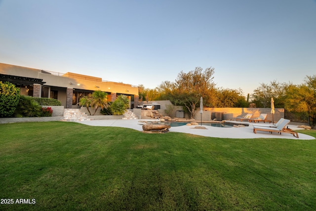 yard at dusk featuring area for grilling, a fenced in pool, and a patio