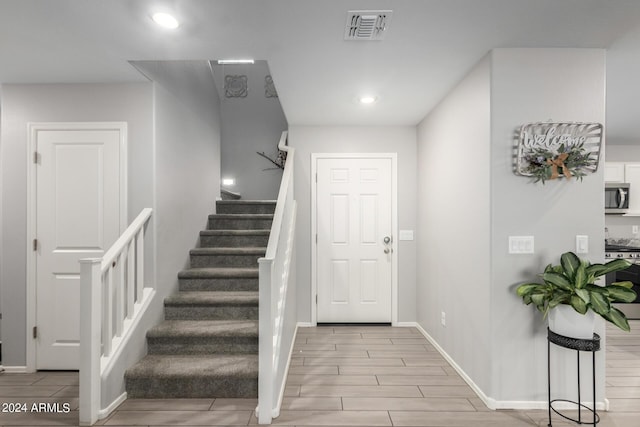 entryway featuring recessed lighting, wood finish floors, visible vents, baseboards, and stairway