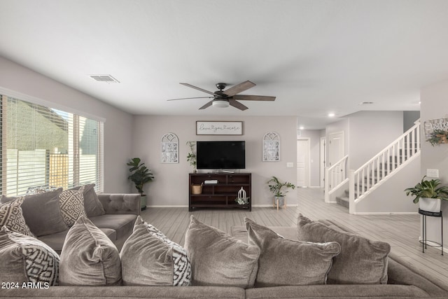 living room featuring ceiling fan and light hardwood / wood-style floors