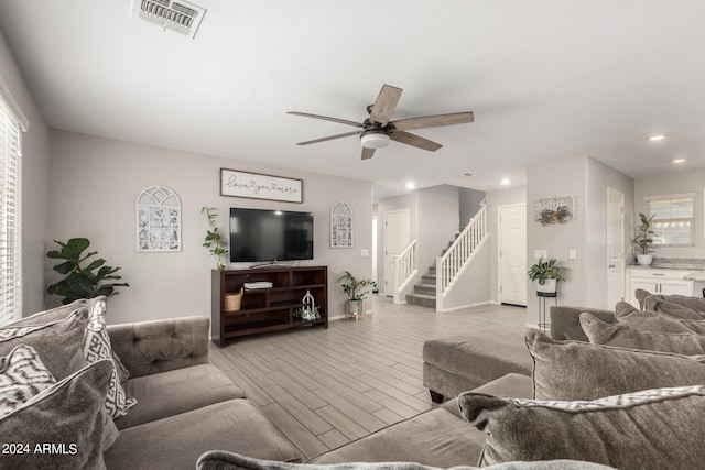 living room with light wood-type flooring and ceiling fan