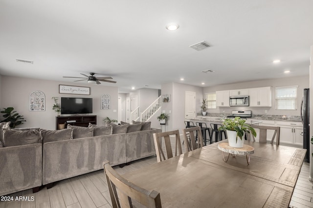 dining space with ceiling fan and light hardwood / wood-style floors