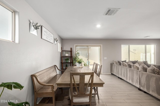 dining area with light wood-style floors, a wealth of natural light, and visible vents