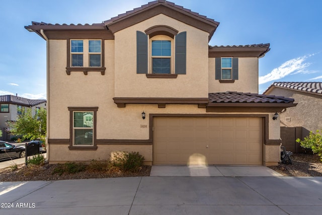 view of front facade with an attached garage, driveway, and stucco siding