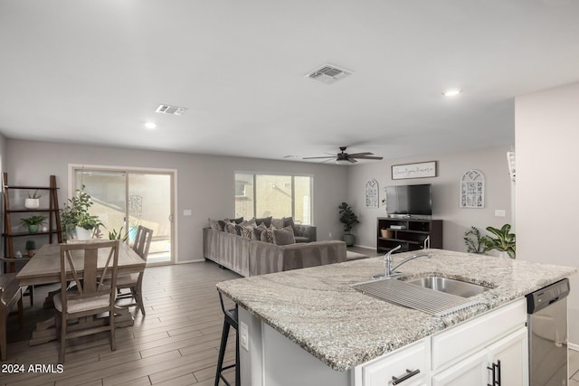 kitchen with dishwasher, a sink, visible vents, and white cabinetry